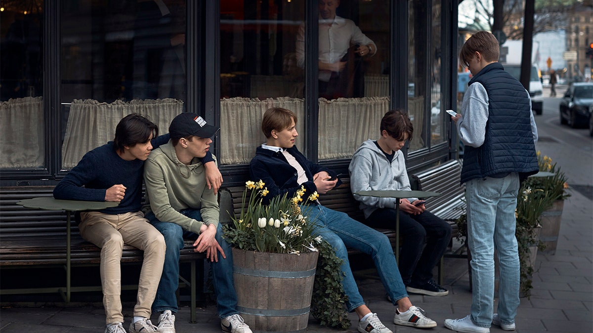FILE - In this Wednesday, April 8, 2020 file photo youths hang out outside a restaurant in Stockholm, Sweden. (AP Photo/Andres Kudacki, File)