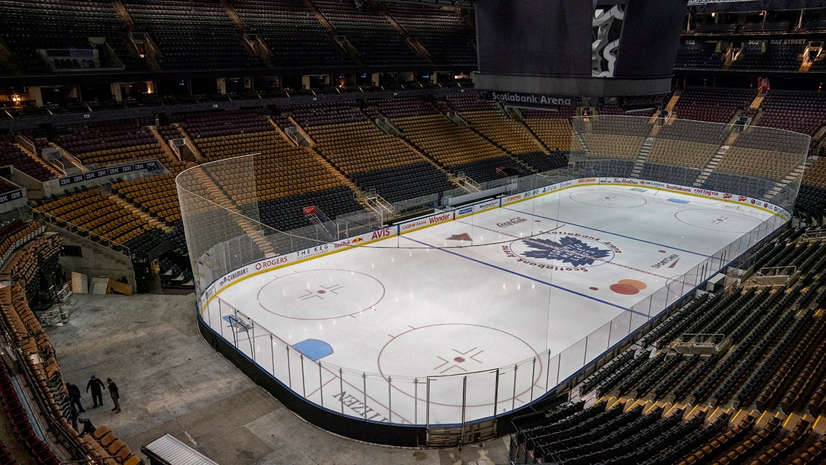 Workers stand by after pausing the assembly of the arena for the Maple Leafs NHL hockey game against the Nashville Predators at Scotiabank Arena in Toronto in March. When sports finally emerge from their slumber following the coronavirus pandemic, one physician believes proof of immunity can eventually be a way to ensure the safety of those who attend certain arenas. (Frank Gunn/The Canadian Press via AP, File)