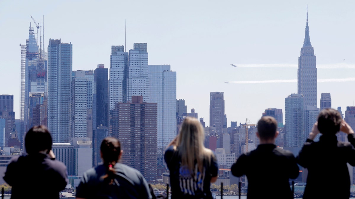 People watch the aircraft pass in front of the New York City skyline as seen from Weehawken, N.J., on Tuesday. (AP)