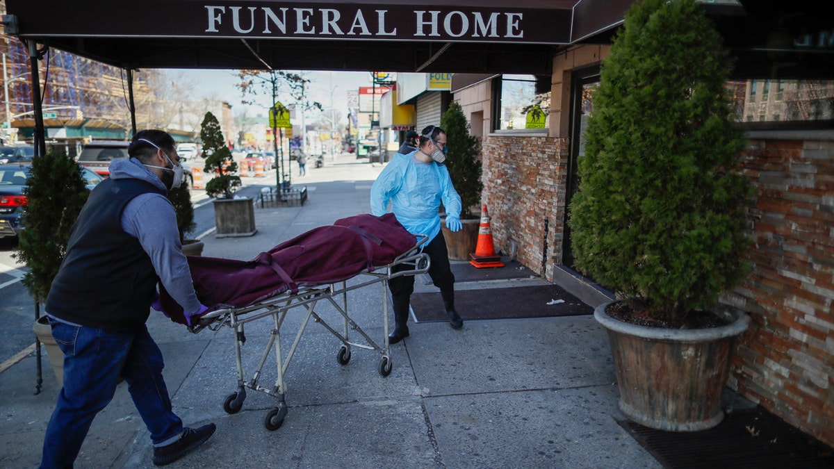 Employees deliver a body at Daniel J. Schaefer Funeral Home, Thursday, April 2, 2020, in the Brooklyn borough of New York City. The company is equipped to handle 40-60 cases at a time. But amid the coronavirus pandemic, it was taking care of 185 Thursday morning. (AP Photo/John Minchillo)