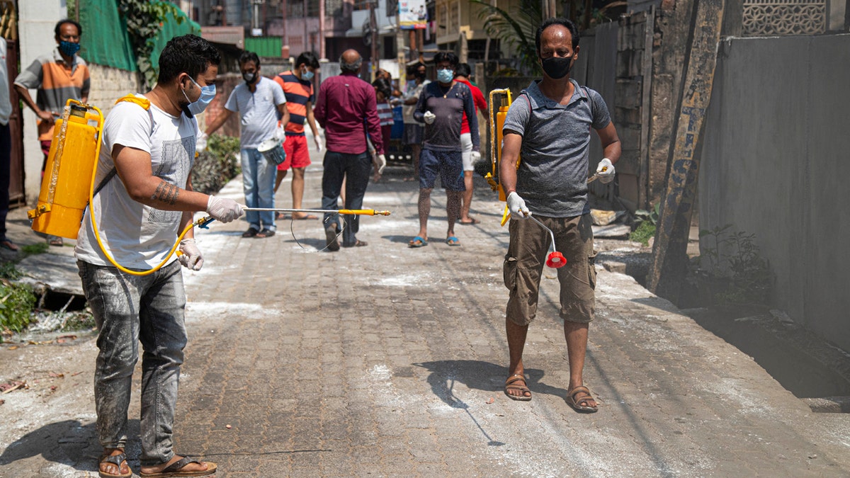 Residents sanitize their area as a preventive measure against the COVID-19 in Gauhati, India, Sunday, April 5, 2020.