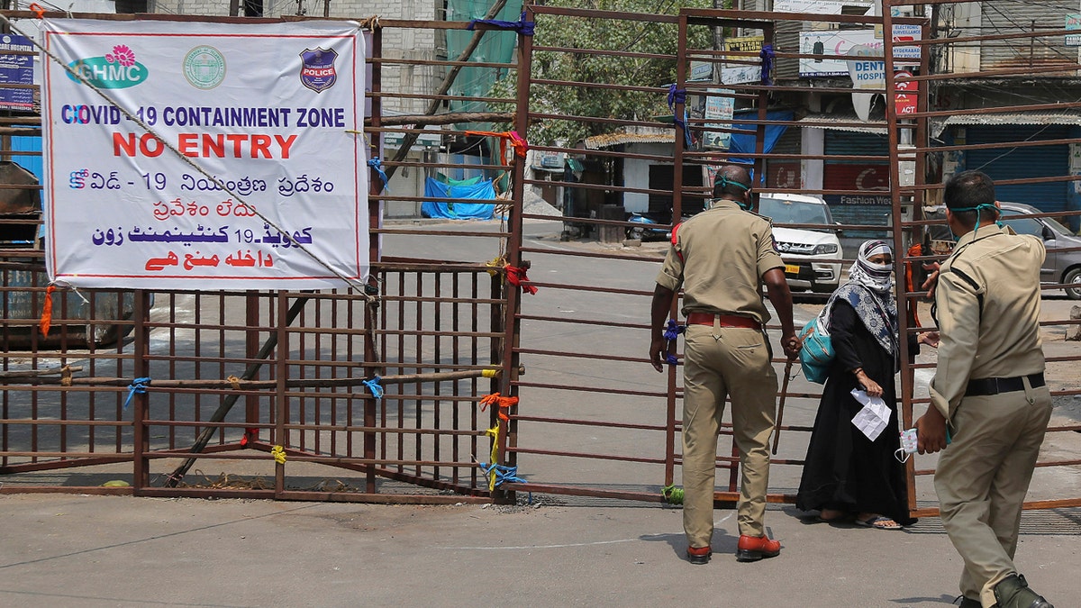 Policemen stop a woman from entering a containment zone during lockdown in Hyderabad, India, April 14.