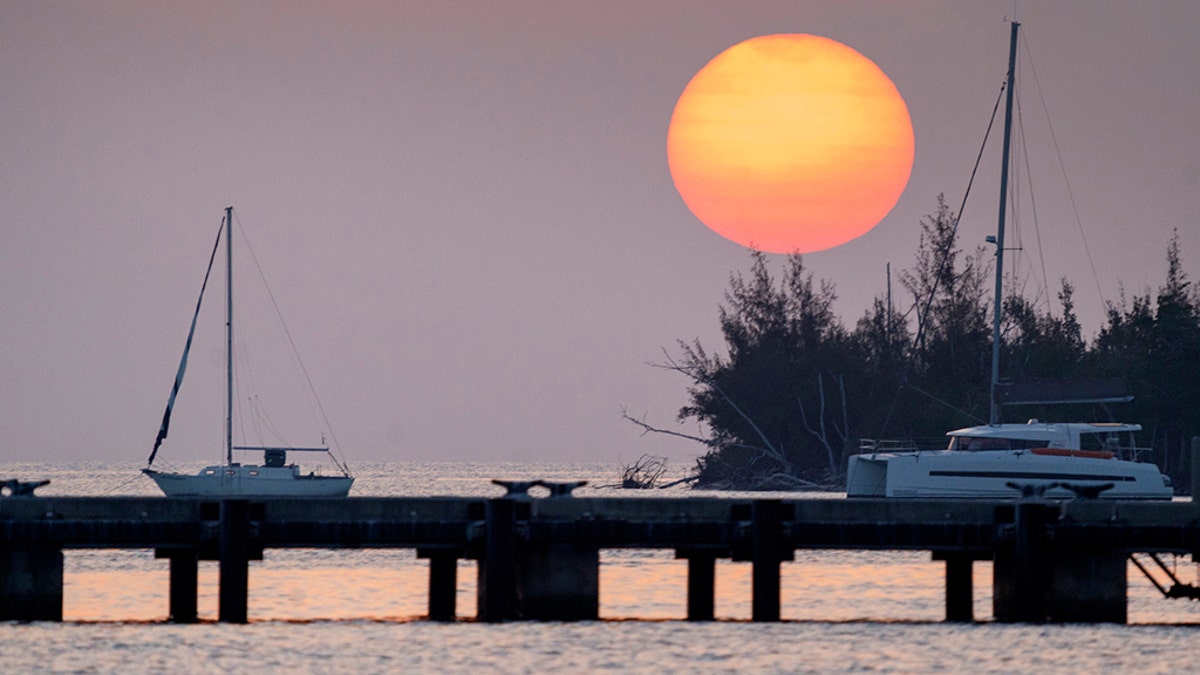The sun sets Friday, April 17, 2020, over a quiet Key West Harbor in Key West, Fla. Gov. Ron Desantis opened Florida beaches Friday as a first move to reopen the state after the coronavirus outbreak. (Rob O'Neal/The Key West Citizen via AP)
