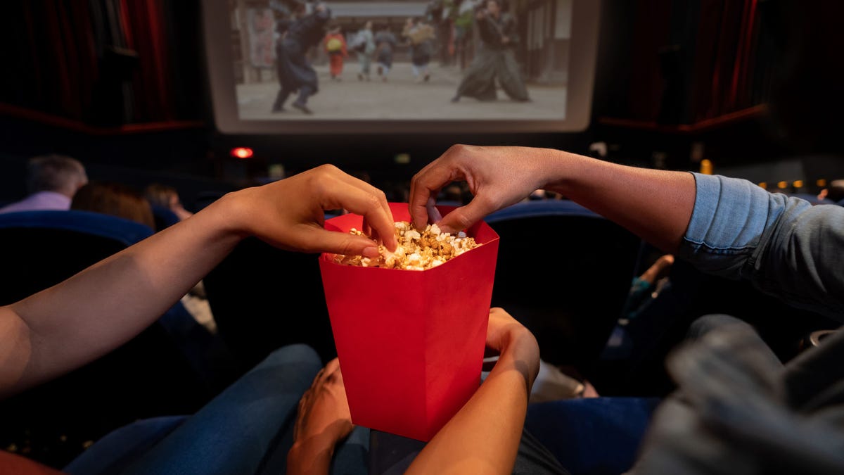 Close-up on a couple at the movies eating popcorn