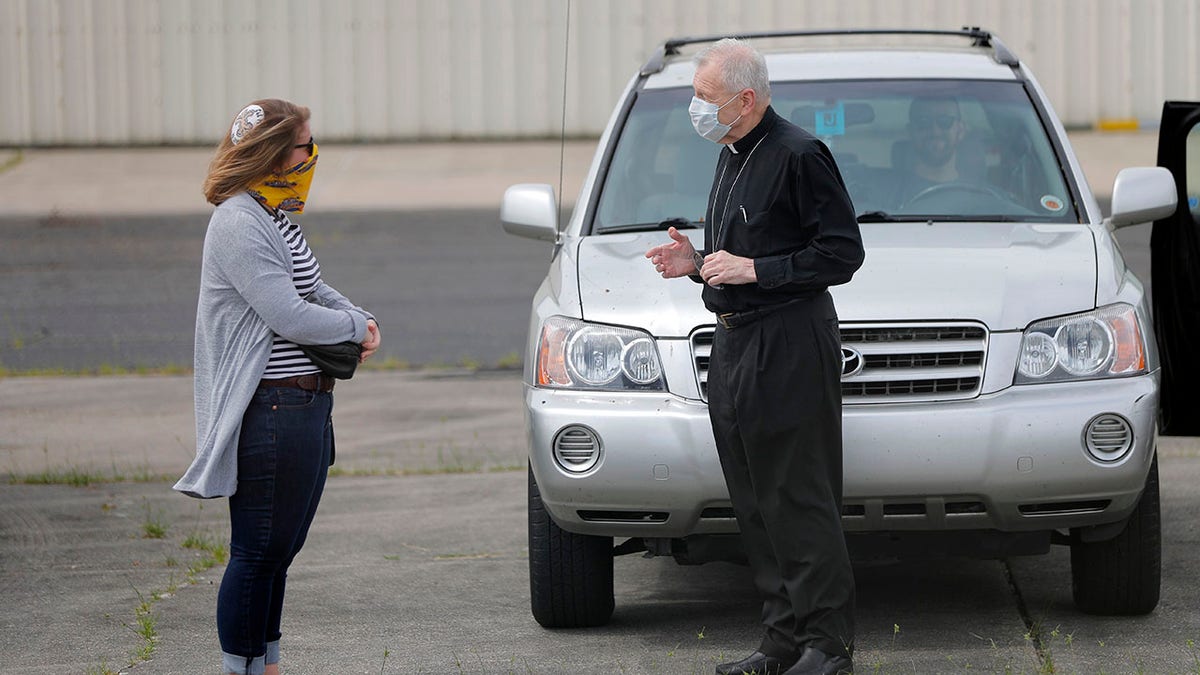 Aymond talks with Rabbi Lexi Erdheim after he flew over the city to bless victims of the coronavirus. Erdheim flew next and gave blessings for those affected by the virus during Passover. (AP Photo/Gerald Herbert)