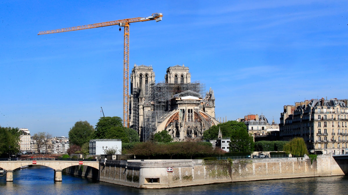 A crane stands by Notre Dame Cathedral on April 15. Work began Monday to refit the construction site to protect workers from the virus and allow cleanup efforts to resume. (AP)