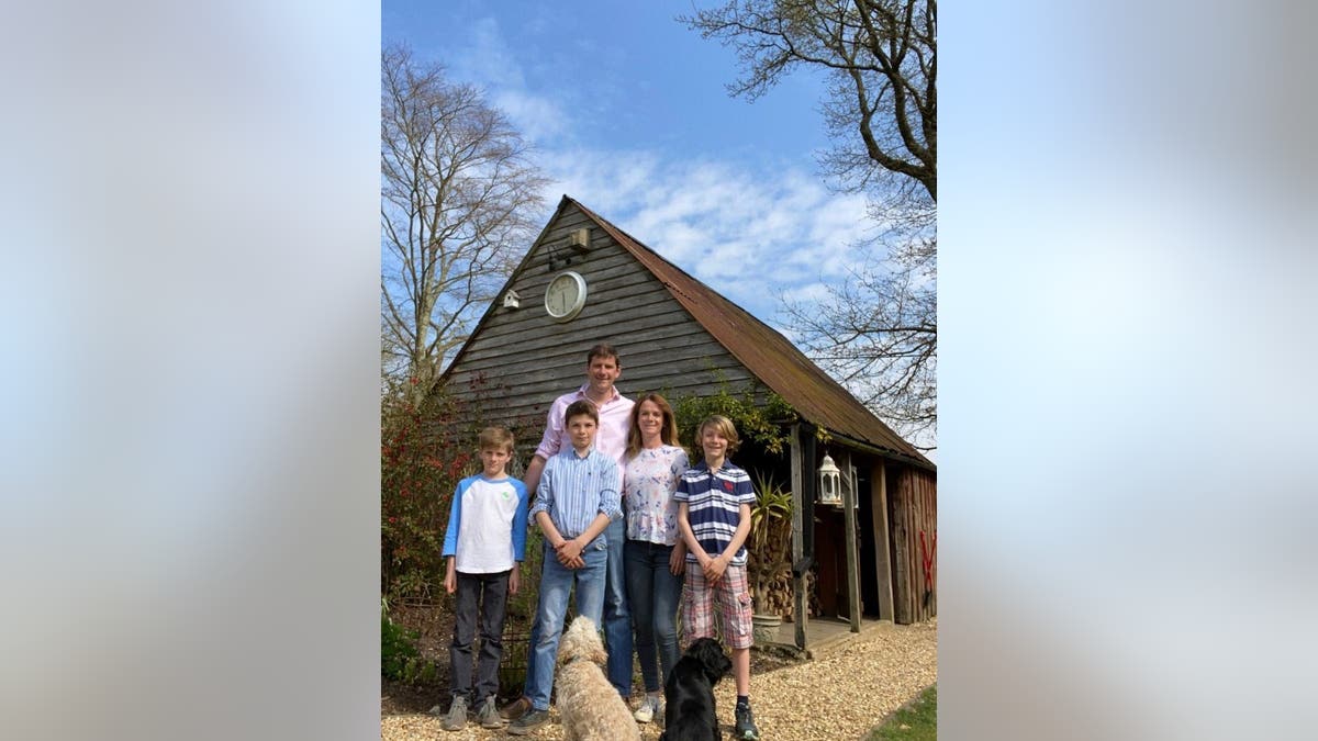 The Bubear family (left to right Ned, Olliem Charlie, Alice and Jake) watch as a WW1 grenade is removed from the gutter of their house. (Credit: SWNS)