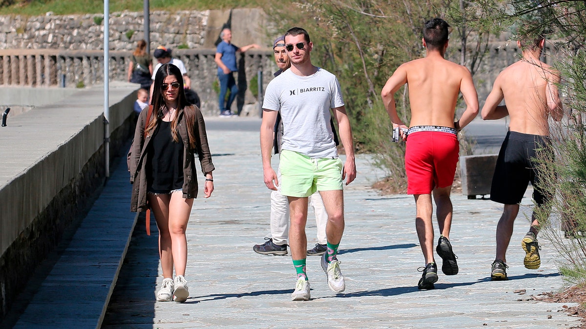 People walk near the beach during a nationwide confinement to prevent the spread of the coronavirus, in Biarritz, France, Saturday April 4, 2020.