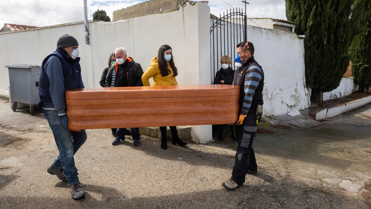 Undertakers carry the coffin of Rosalia Mascaraque, 86, during the coronavirus outbreak in Zarza de Tajo, central Spain, Wednesday.