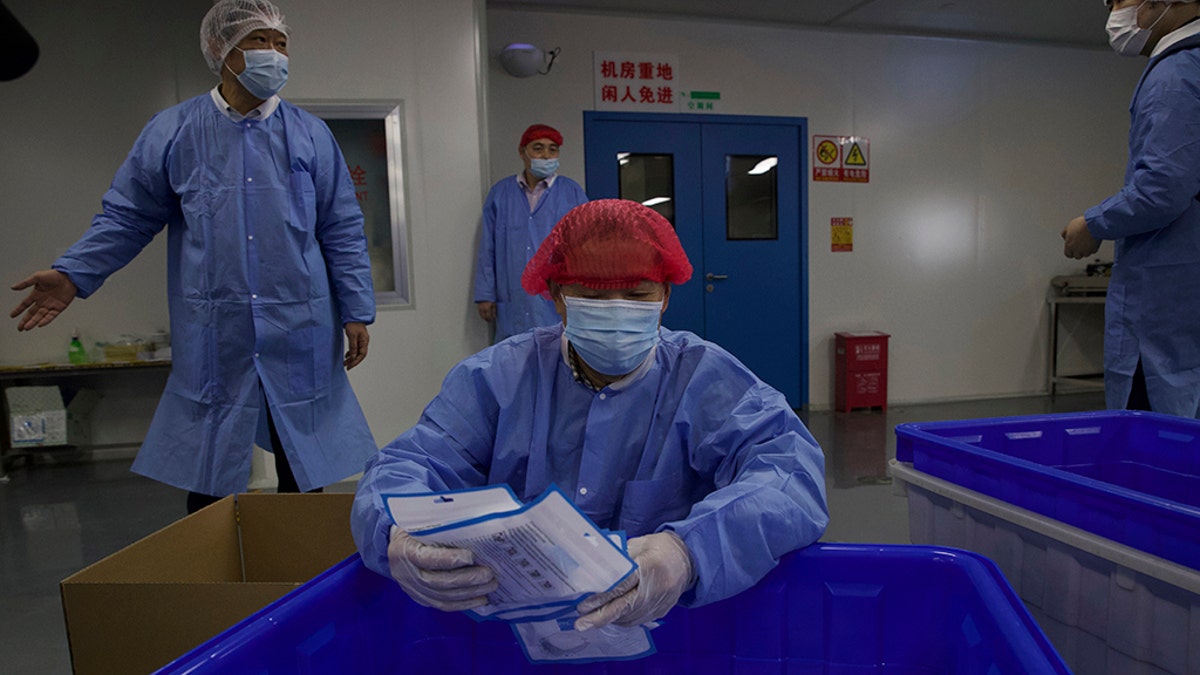 A worker packs finished masks in a production line for the Wuhan Zonsen Medical Products Co. Ltd. in Wuhan, in central China's Hubei province Sunday, April 12, 2020. Chinese regulators say ventilators, masks and other supplies being exported to fight the coronavirus will be subject to quality inspections following complaints shoddy or substandard goods were being sold abroad. (AP Photo/Ng Han Guan)