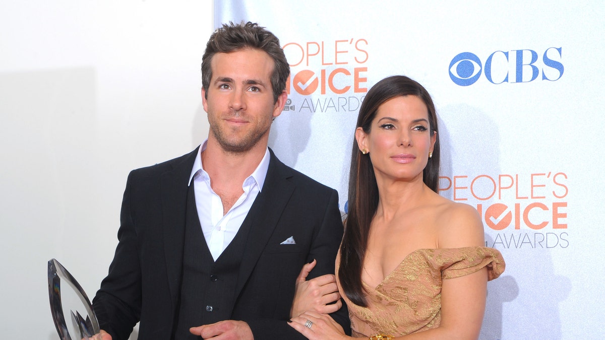 Ryan Reynolds (L) and actress Sandra Bullock pose with the Favorite Comedy Movie award for 'The Proposal' in the press room during the People's Choice Awards 2010.