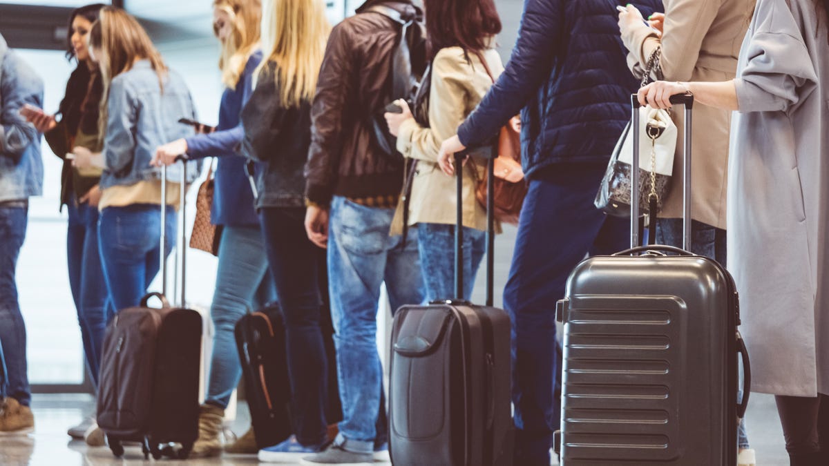 Group of people standing in queue at boarding gate