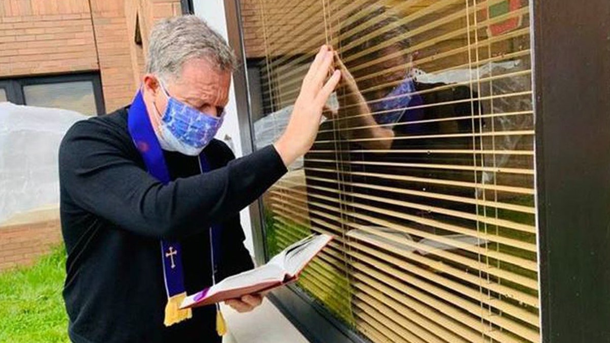 Rev. Michael Way of Christ Episcopal Church in Middletown, New Jersey, recited the last rites through a window for a parishioner in the nursing home.