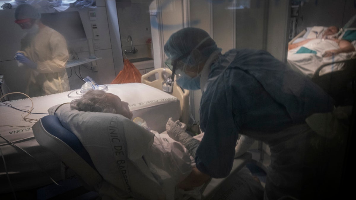 Health care workers assist a COVID-19 patient at one of the intensive care units (ICU) of the Clinic hospital in Barcelona, Spain, on Wednesday. (AP Photo/Ricardo Garcia Vilanova)