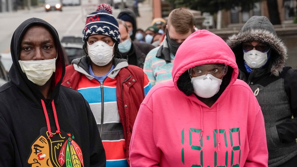 Voters masked against coronavirus line up at Riverside High School for Wisconsin's primary election Tuesday April 7, 2020, in Milwaukee. The new coronavirus causes mild or moderate symptoms for most people, but for some, especially older adults and people with existing health problems, it can cause more severe illness or death. (AP Photo/Morry Gash)