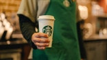 Barista holding coffee cup.
