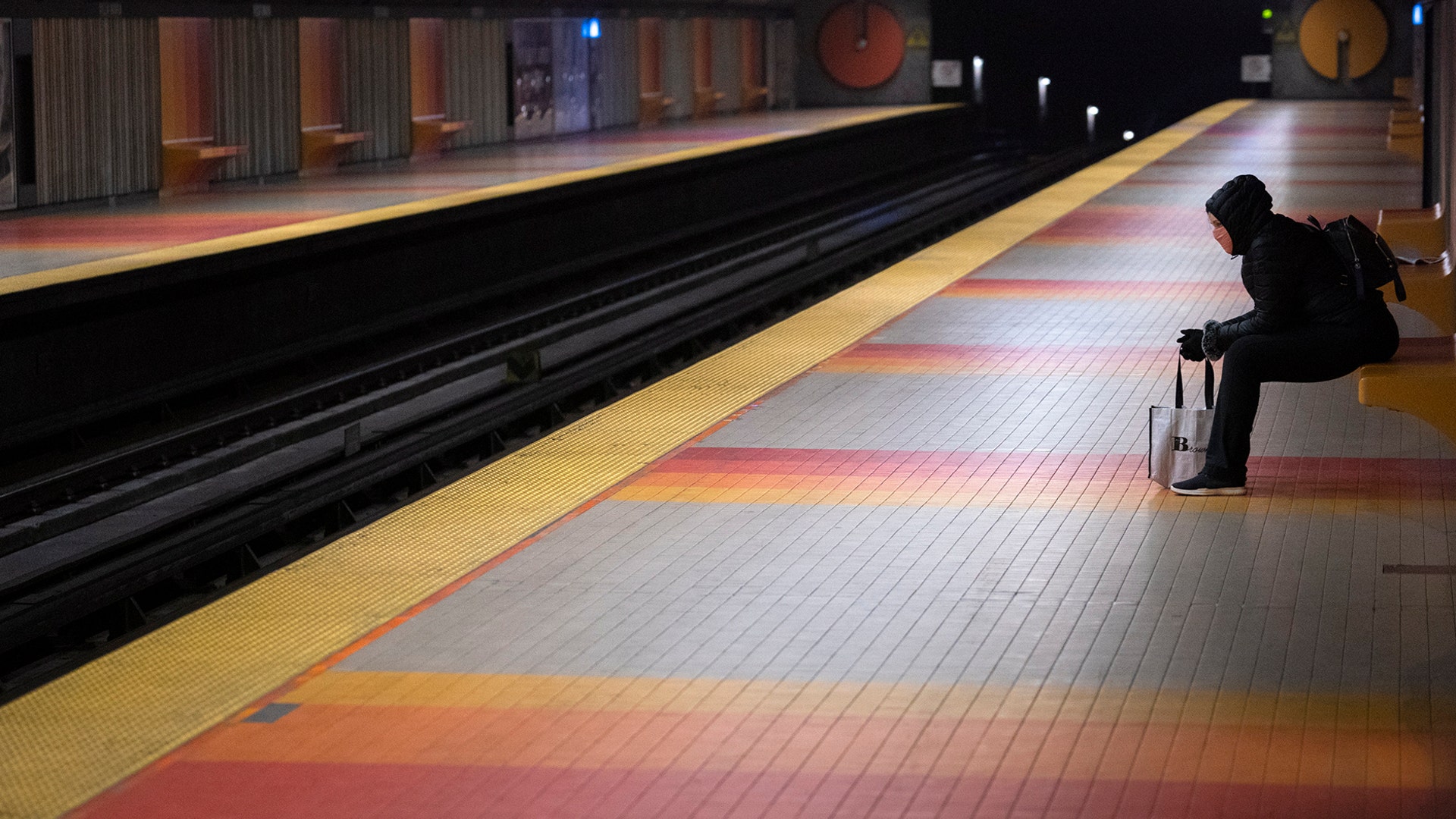A commuter wearing a protective mask waits in an empty subway station in Montreal, April 22, 2020.