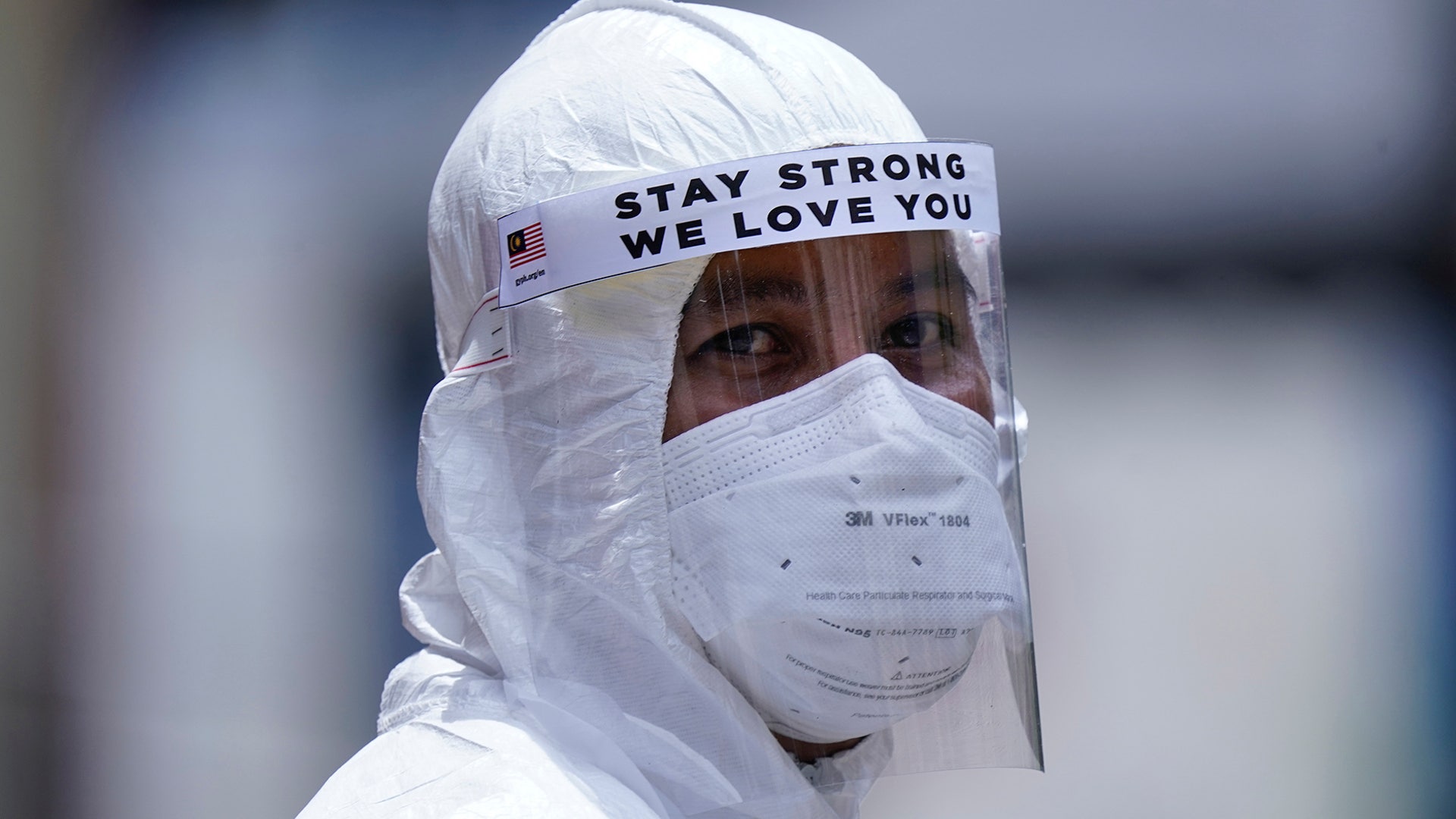 Health staff wear protective equipment to help stop the spread of the coronavirus outside the Menara City One condominium under a lockdown in Kuala Lumpur, Malaysia, April 14, 2020. 
