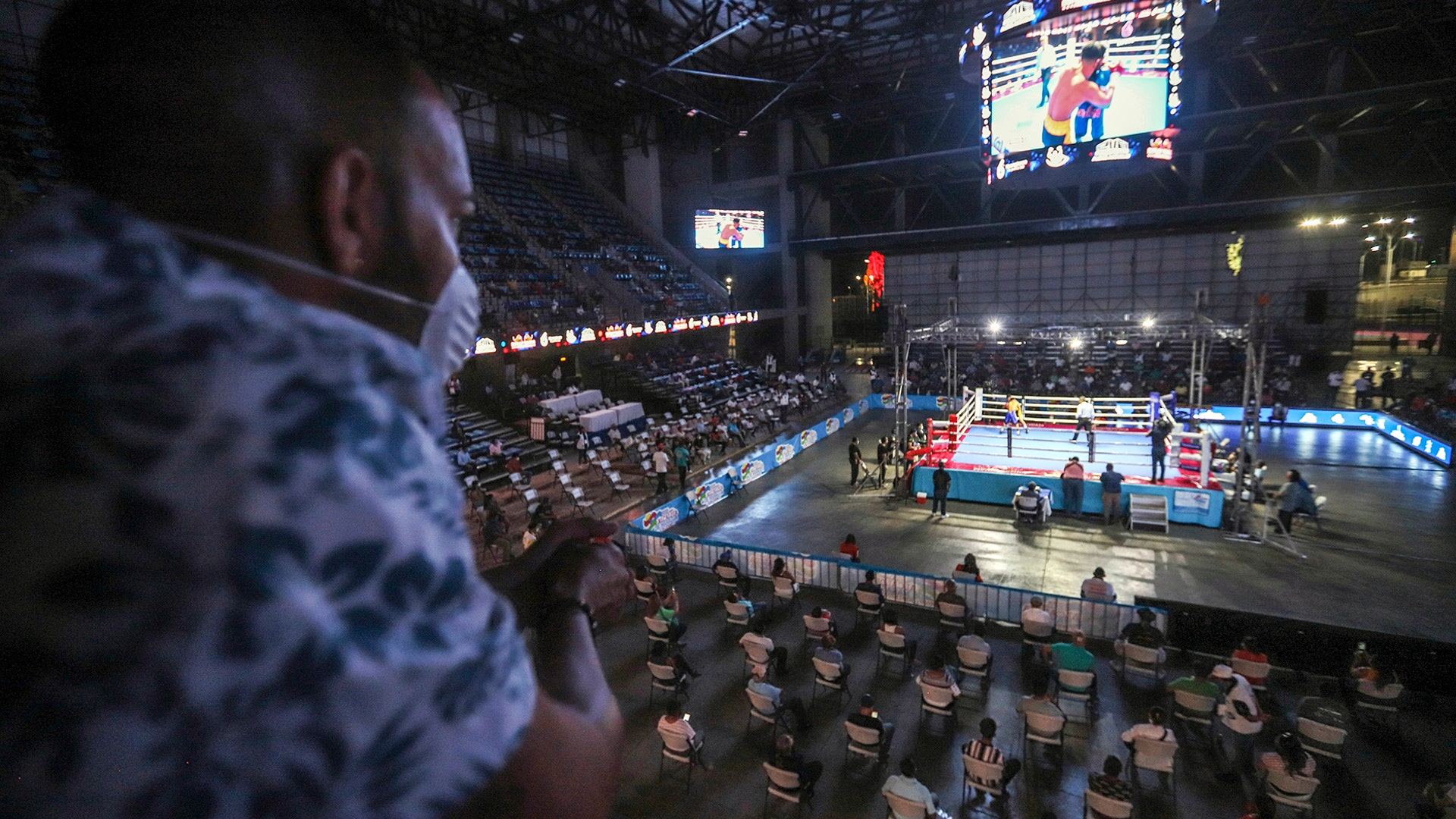 A man wearing a protective face mask looks at a fight organized by Nicaraguan two-time world box champion Rosendo Alvarez in Managua, Nicaragua, April 25, 2020. 