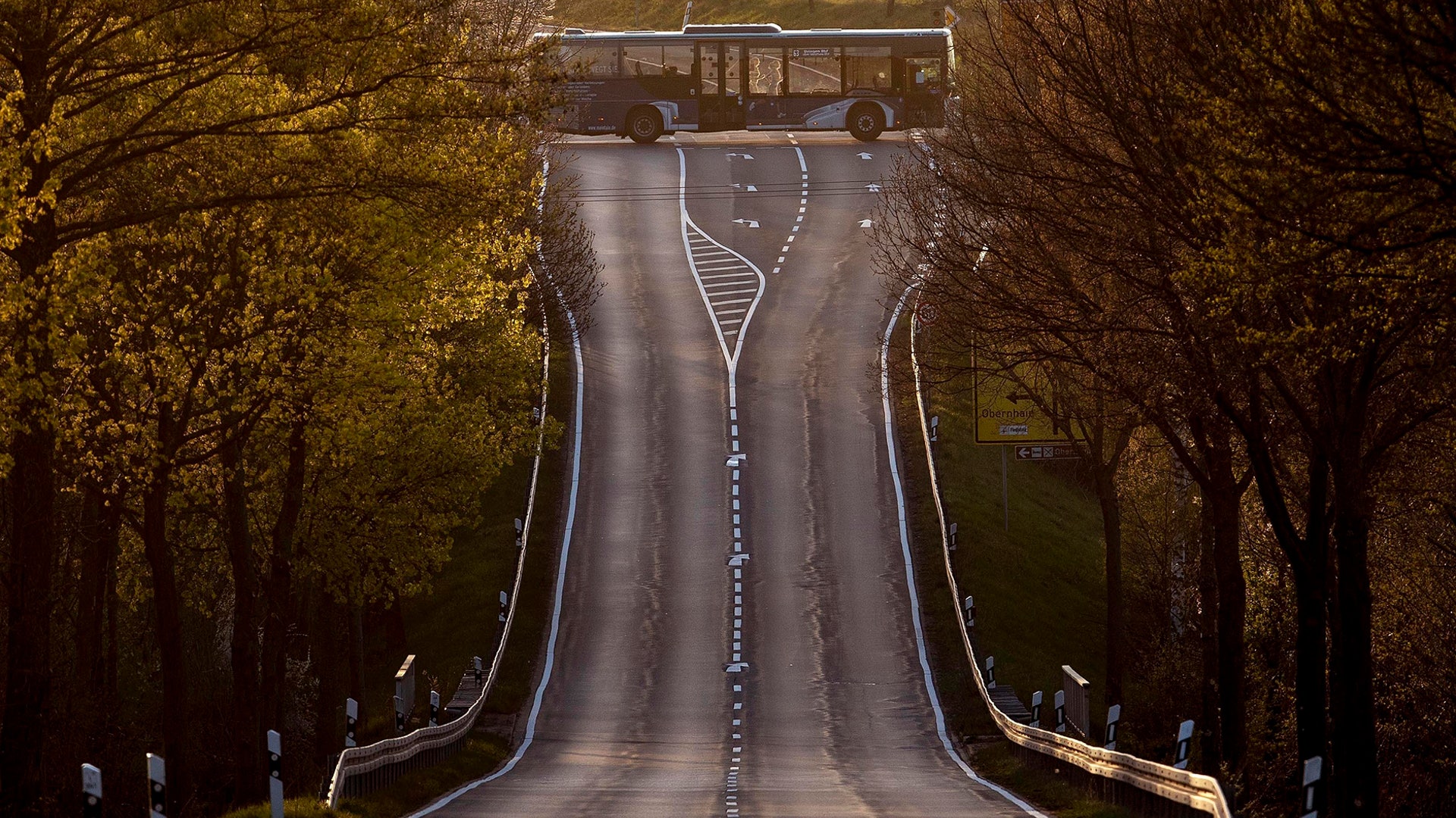 An empty bus crosses an empty road in Obernhain near Frankfurt, Germany, April 14, 2020. 