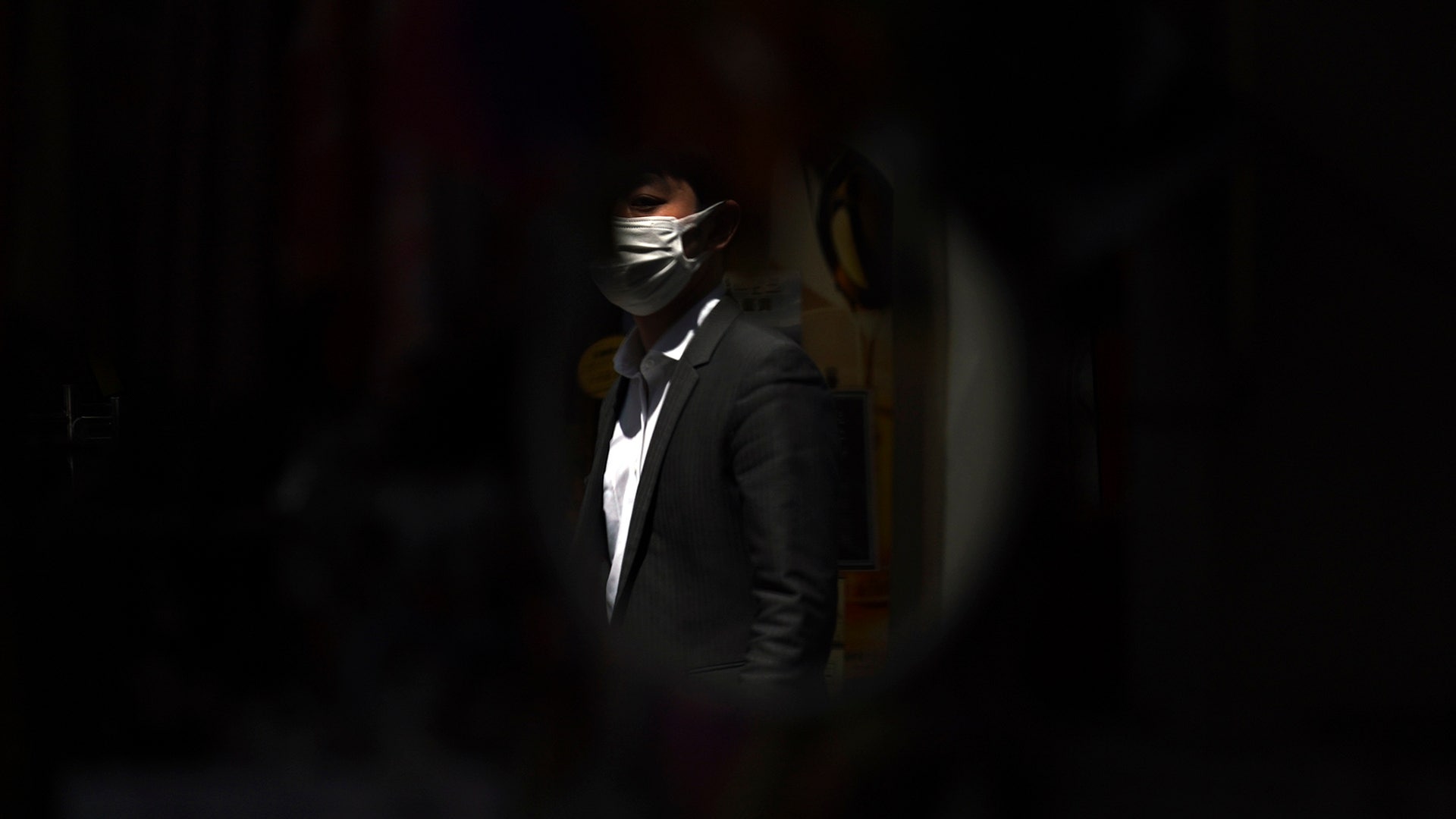 A mirror at a shop reflects a man wearing a protective mask in Tokyo, April 14, 2020. 