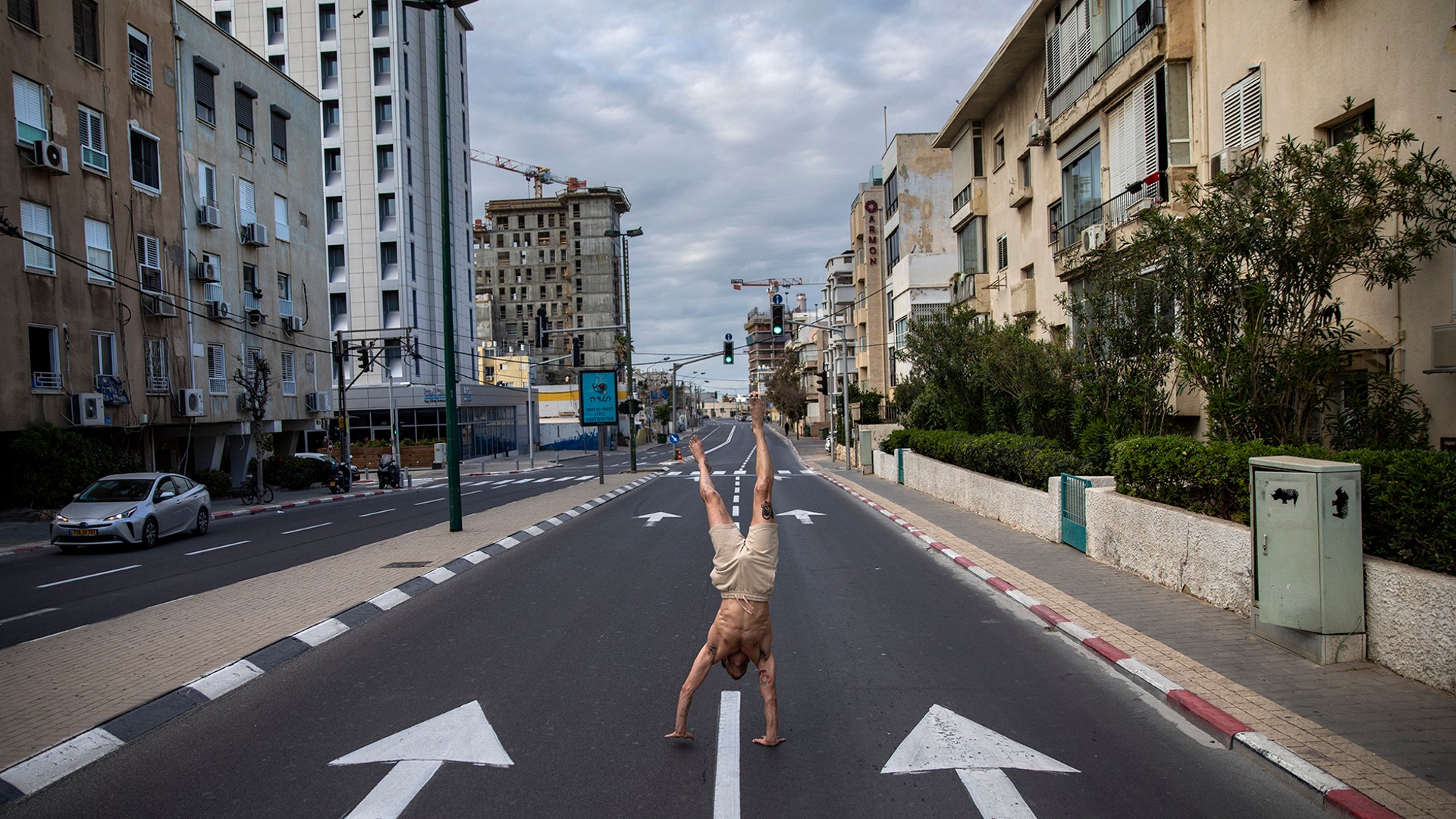 An Israeli man stands on his hands on an empty road during a lockdown following government measures to help stop the spread of the coronavirus, in Tel Aviv, Israel, April 8, 2020.