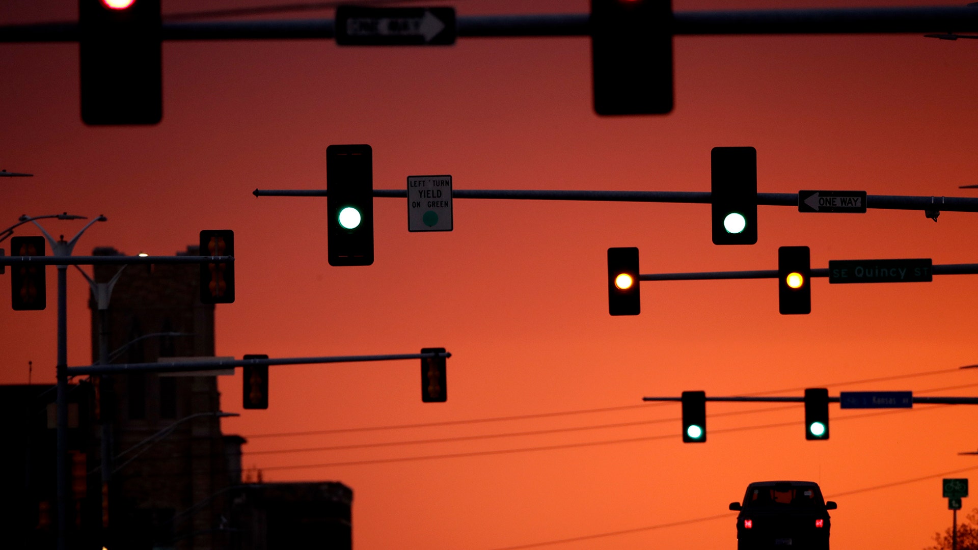 A lone motorist waits at a stoplight on an empty street as the sun sets in Topeka, Kansas, April 28, 2020.