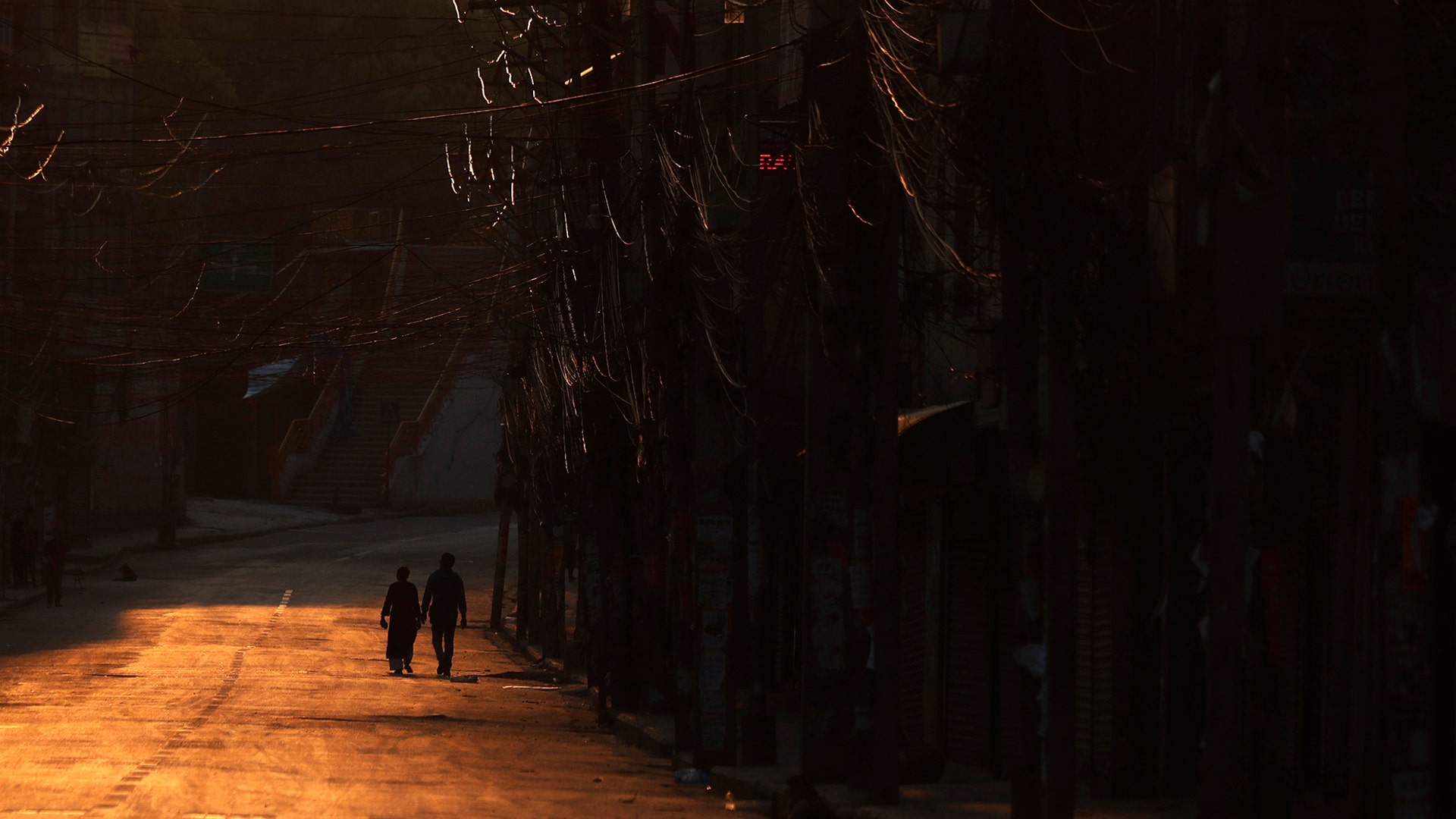 A Nepalese couple walks through a deserted road during lockdown to control the spread of the new coronavirus in Kathmandu, Nepal, April 9, 2020.