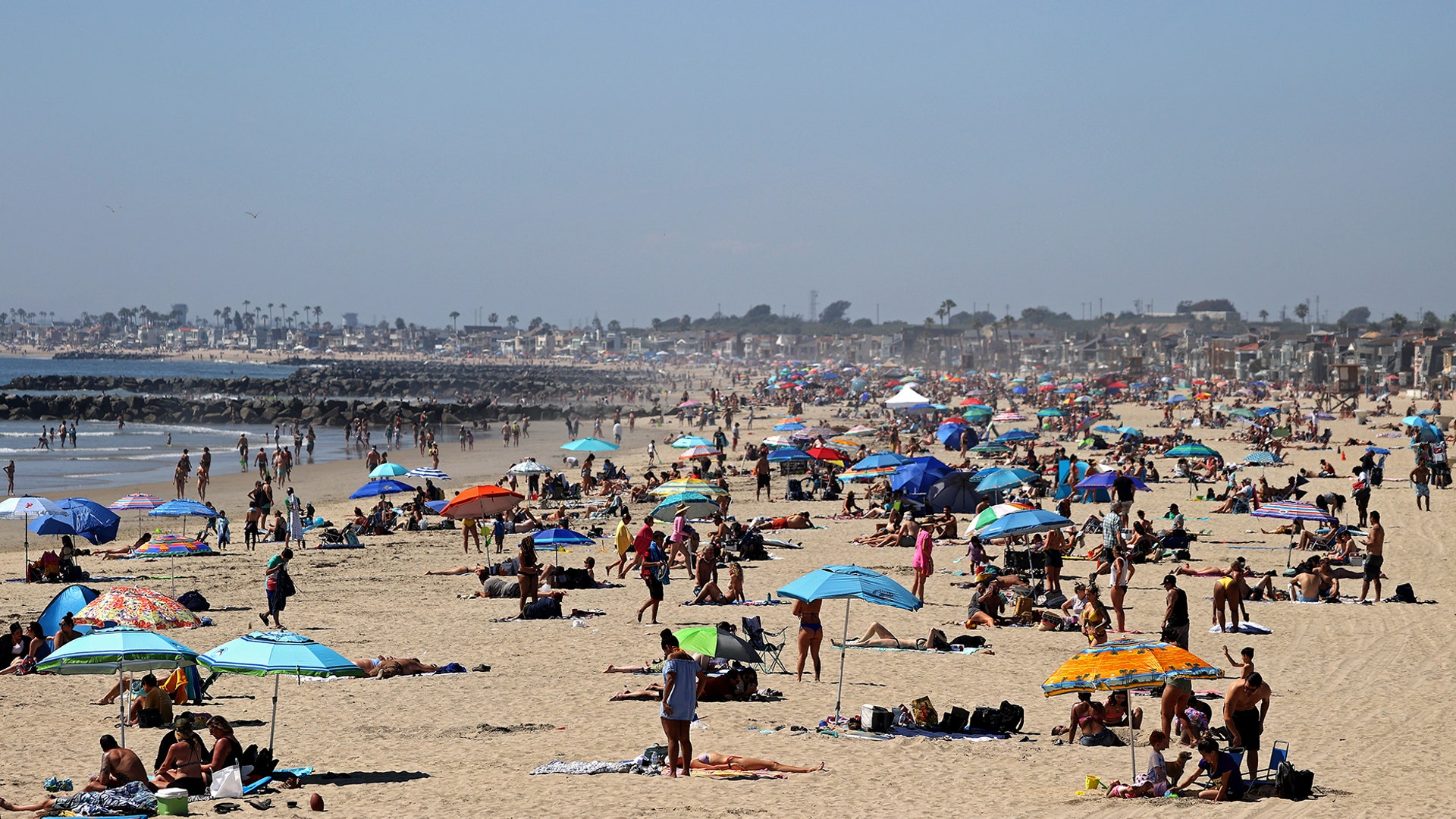 People are seen gathering on the beach north of Newport Beach Pier in Newport Beach, Calif., April 25, 2020. 
