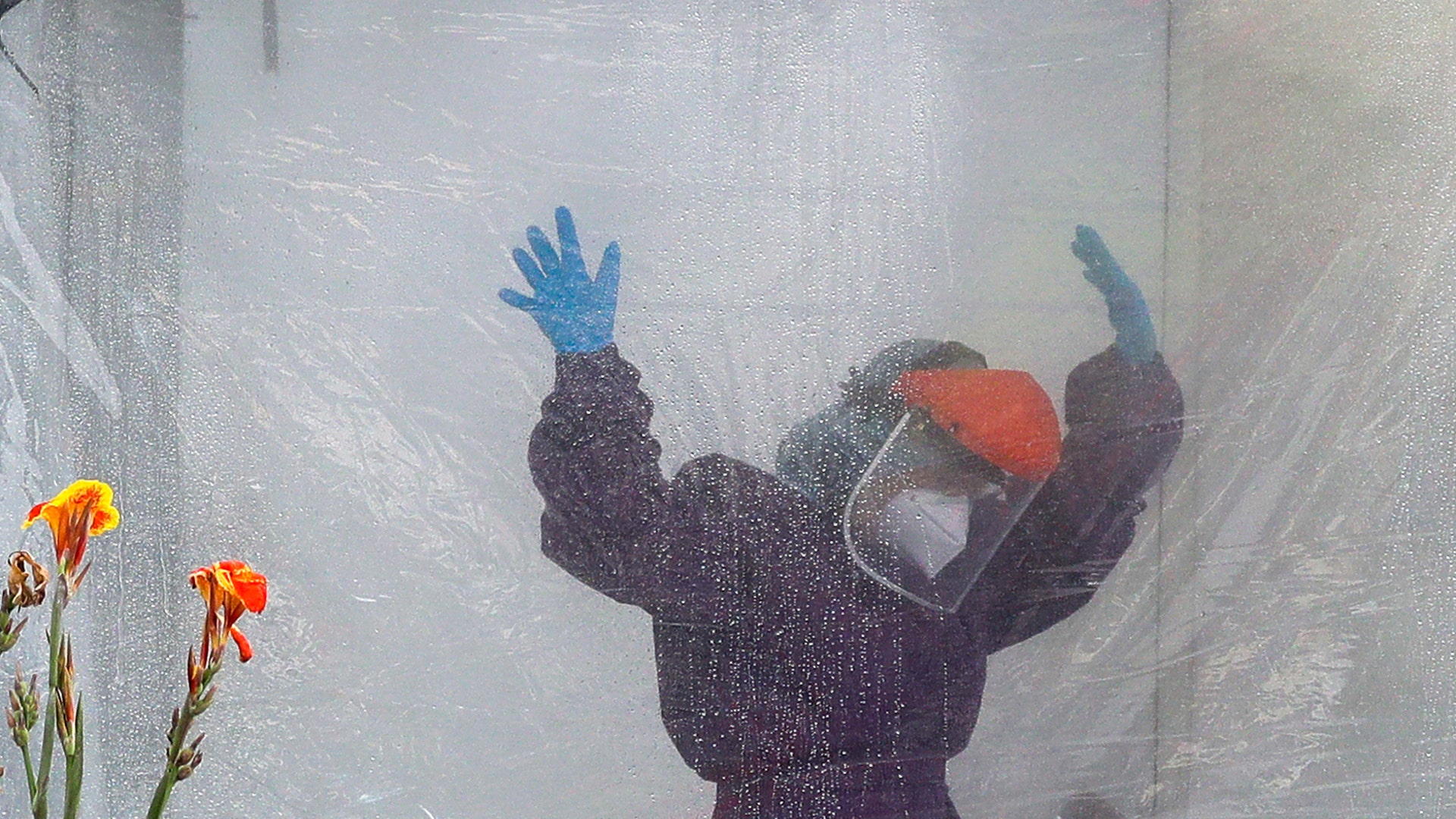 A health worker wearing a protective suit is disinfected inside a portable tent outside the Gat Andres Bonifacio Memorial Medical Center in Manila, Philippines, April 27, 2020. 
