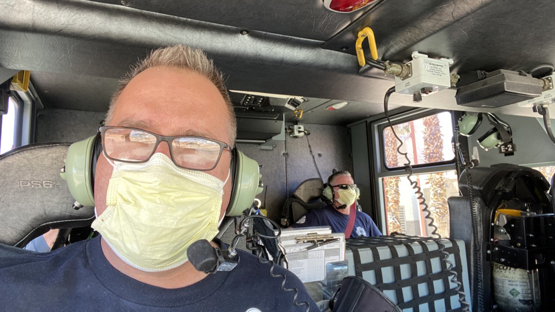 Practicing social distancing inside fire engine 2. Fire personnel in Las Vegas following IAFF guidelines on social distancing in the fire house and on the rigs. Captain Steve Palenske and fireman Dan Wilder wear masks Enroute to a call