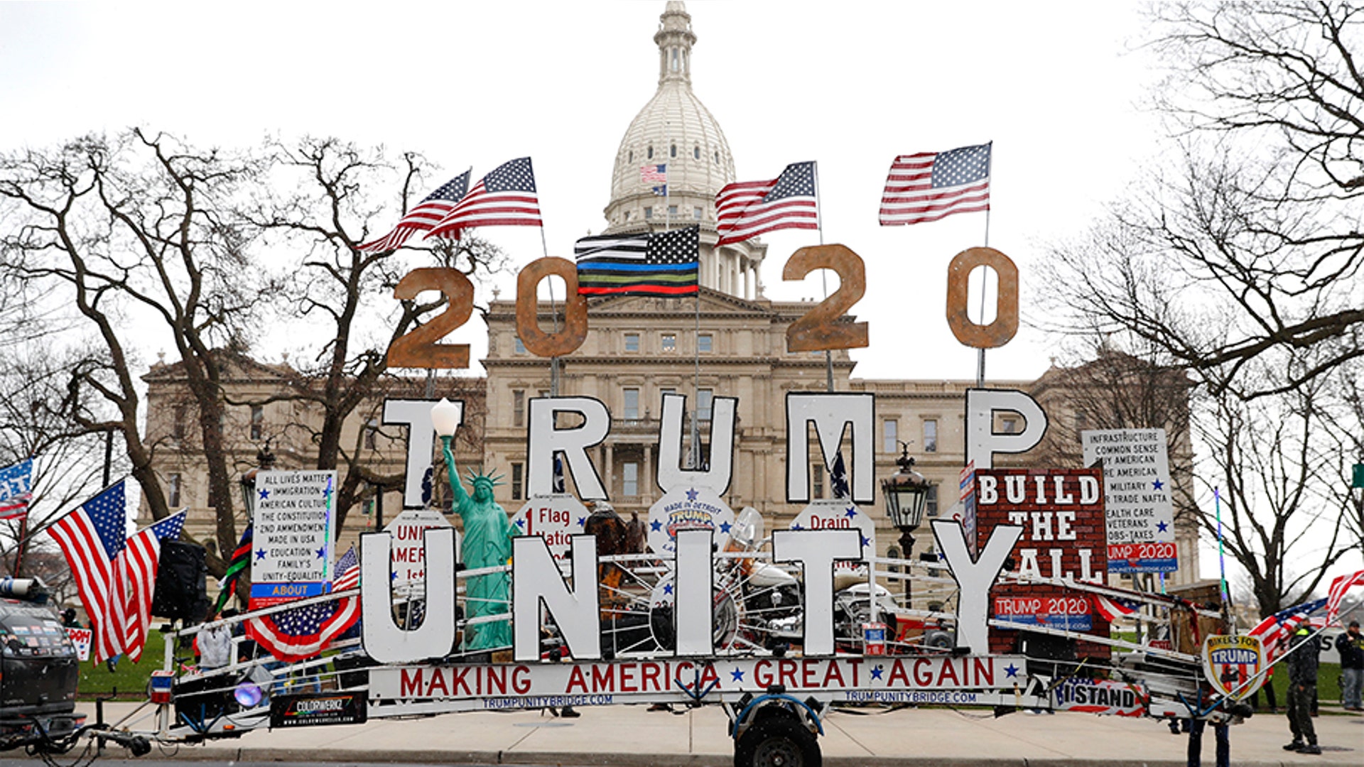 A Trump Unity sign on a trailer is shown parked at the protest in front of the Michigan State Capitol in Lansing.
