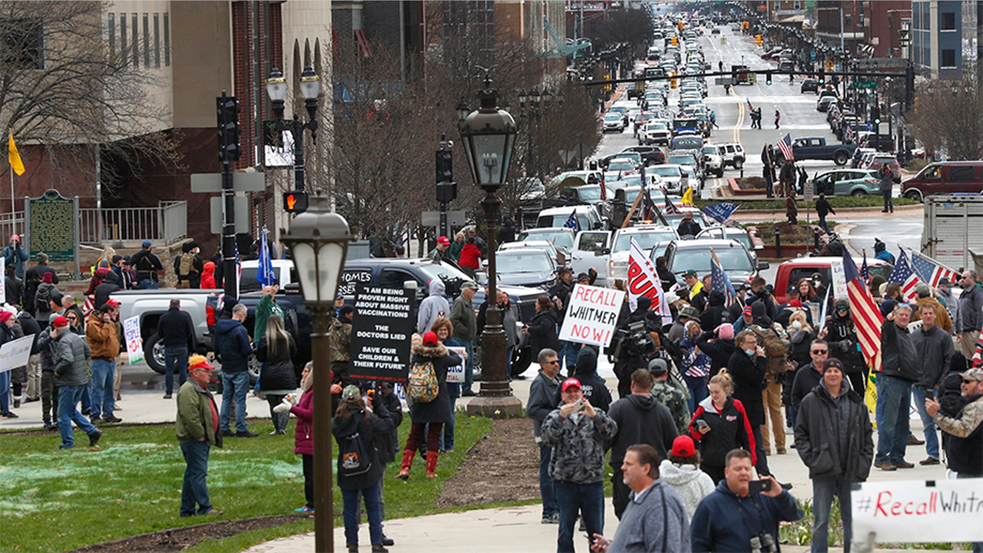 Protesters gather at the Michigan State Capitol in Lansing, Mich., Wednesday, April 15, 2020. Flag-waving, honking protesters drove past the Michigan Capitol on Wednesday to show their displeasure with Gov. Gretchen Whitmer's orders to keep people at home and businesses locked during the new coronavirus COVID-19 outbreak.