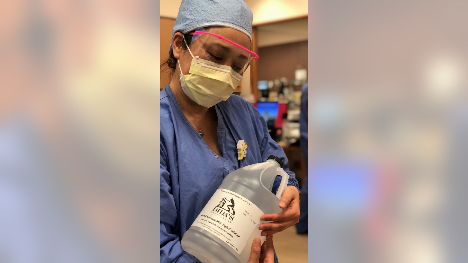 Nurse at Sibley Memorial, Washington D.C, cradles a bottle of donated hand sanitizer. That hand sanitizer was made from grapes, and funded by the community.