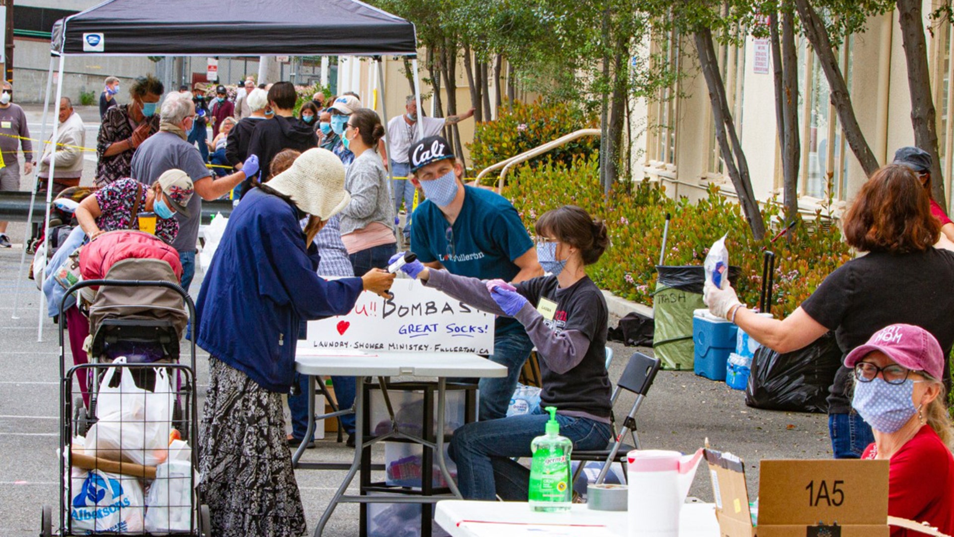 Along with the shutdown of most of the country, many community homeless services have, for the most part, been shut down too. The Shower &amp; Laundry Ministry in Fullerton, CA was able to proved modified services on Saturday April 4th. This is a great example of "America Together" - giving of oneself to those have almost nothing. Masks, gloves, sanitizer, taped social distancing lines and 18 dedicated volunteers provided a boxed meal, water bottles, quarters and laundry pods, underwear, Bombas donated socks, and plastic bags to protect their belongings against the expected SoCal rains. The turnout was about 2X (80+) of what we normally have - a sign of the times due to diminished homeless service opportunities. My wife, Marsha, coordinates this small ministry with a great group of volunteers that reach across many of the local area churches. Funded by donations only, they are able to scrape by each month with a very tight budget and volunteer donated items like food, hygiene items, and clothing. This ministry normally provides a shower trailer, laundry service (guests drop off the clothes and volunteers wash and fold), a warm meal, clothes, hygiene items, and, most of all, compassion given by volunteers who provide a loving dose of conversation and humanity. An opportunity for the guests to just be 'normal' and safe for a few hours twice a month. A couple of her volunteers started out as guests, have escaped the streets, and now give back to those who remain homeless. With the closing of libraries, community centers, parks, indoor fast food restaurants, grocery store restrooms, and gyms - the hard life of being homeless has gotten exponentially harder. The stresses have grown and it shows in their eyes and on their faces. The appreciation given back by the guests is evident in the smiles and many heartfelt 'thank you so much' being offered.