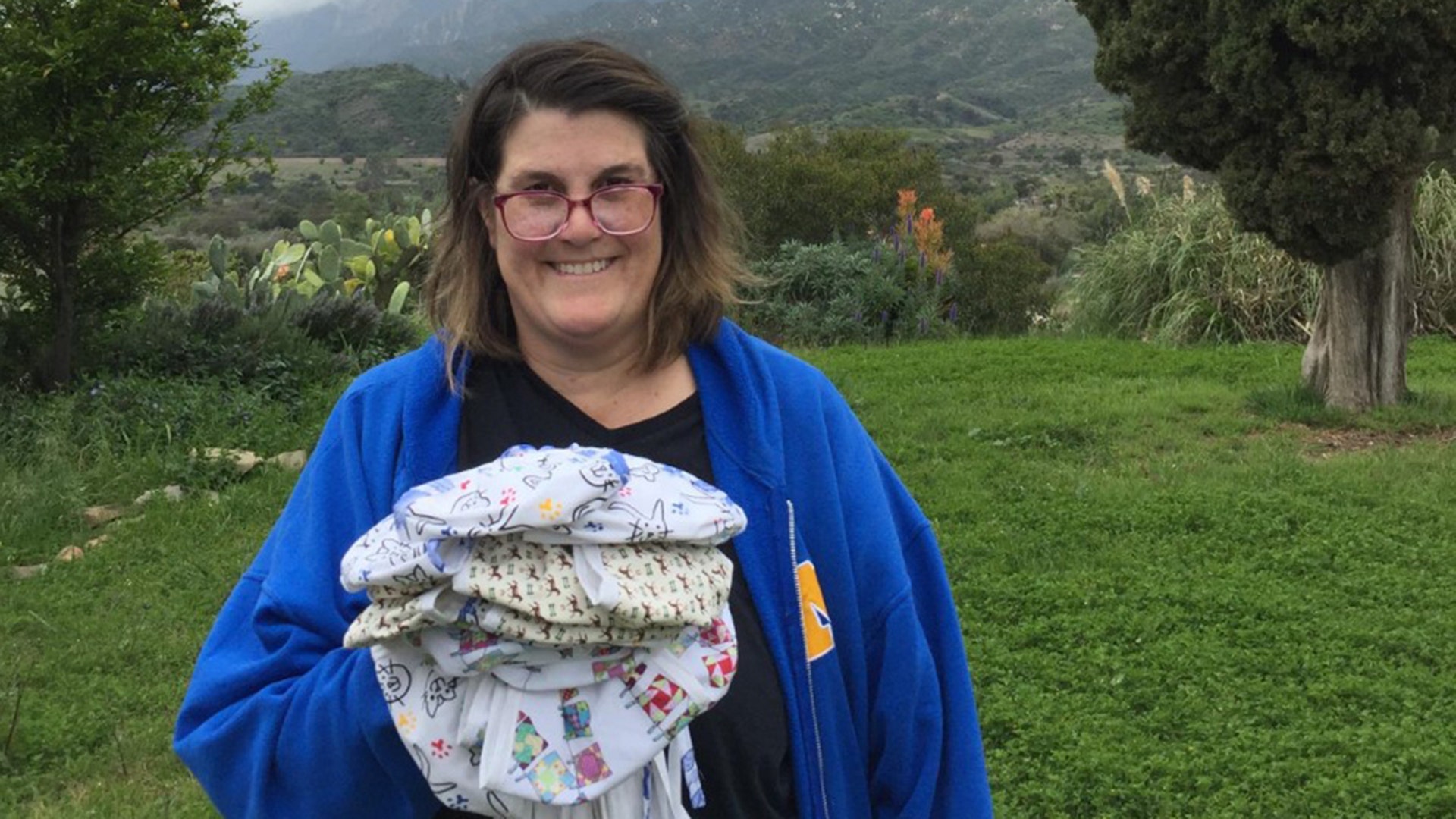 My name is Paige Johnson. I live in Ojai, California. I make cotton masks for local hospitals. This picture was taken in my backyard on March 28, 2020. I am holding 23 cotton masks that I made for a hospital in Ventura County, California