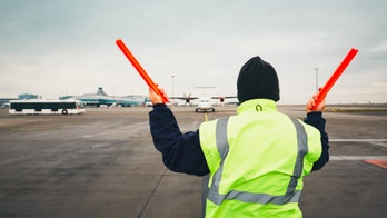 Airline ground crew in Florida holds up signs thanking customers as nearly empty plane prepares to take off
