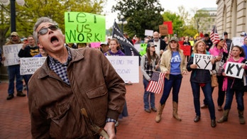 Kentucky sees spike in coronavirus cases, prompting Beshear to keep lockdown in place despite protests