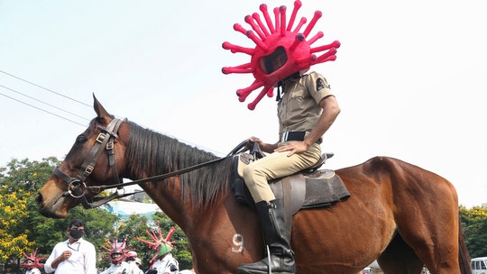 Police in India raise coronavirus awareness with virus costumes while directing traffic, on patrol