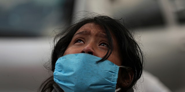 Aurora Guadalupe Azamar reacts after learning that her mother died, probably of COVID-19 disease, outside of a public hospital at Iztapalapa, Mexico City, Wednesday, April 29, 2020. At hospitals across the capital where coronavirus patients are being treated, family members of the sick crowd the sidewalk outside, with most saying they have no other way of getting information about their loved ones isolated inside. Mexico's coronavirus cases have begun rising more rapidly, with experts predicting a peak around the second week in May. (AP Photo/Fernando Llano)