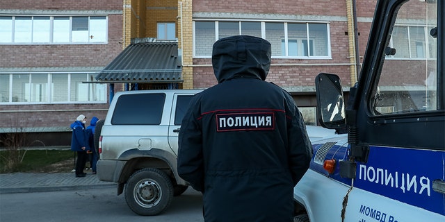 Police at the site of a deadly shooting in an apartment building in the village of Yelatma, Russia.