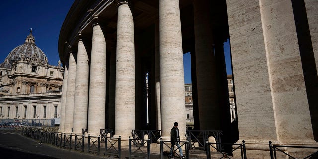 A man walks by Bernini's colonnade in St. Peter's Square during Pope Francis' weekly general audience, streamed by the Vatican television due to restrictions to contain the Covid-19 virus, at the Vatican, Wednesday, April 1, 2020. (Associated Press)