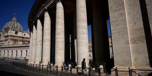 A man walks by Bernini's colonnade in St. Peter's Square during Pope Francis' weekly general audience, streamed by the Vatican television due to restrictions to contain the Covid-19 virus, at the Vatican, Wednesday, April 1, 2020. (Associated Press)