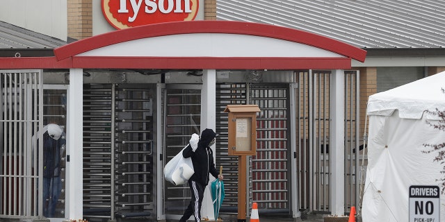A Tyson Fresh Meats plant employee leaves the plant, April 23, in Logansport, Ind. The plant will temporarily close its meatpacking plant in north-central Indiana after several employees tested positive for COVID-19. (AP Photo/Darron Cummings)