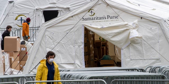 A Samaritan's Purse crew and medical personnel work on preparing to open a 68 bed emergency field hospital specially equipped with a respiratory unit in New York's Central Park, Tuesday, March 31, 2020, in New York. (AP Photo/Mary Altaffer)