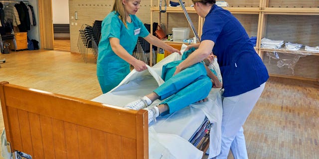 Former Scandinavian Airlines flight attendants learn basic skills on to assist in nursing homes and hospitals due to the coronavirus outbreak, in Stockholm.