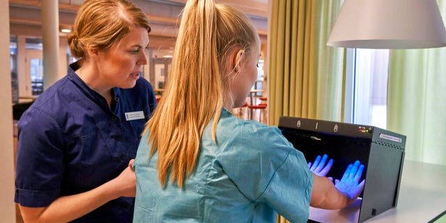 Former Scandinavian Airlines flight attendant, Mathilda Malm tests her hands for bacteria as she learns basic skills on to assist in nursing homes and hospitals due to the coronavirus outbreak, in Stockholm.