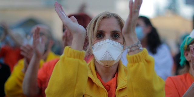 Health workers applaud as people react from their houses in support of the medical staff that are working on the COVID-19 virus outbreak at the Gregorio Maranon hospital in Madrid, Spain, Wednesday, April 1, 2020. The new coronavirus causes mild or moderate symptoms for most people, but for some, especially older adults and people with existing health problems, it can cause more severe illness or death. (AP Photo/Manu Fernandez)