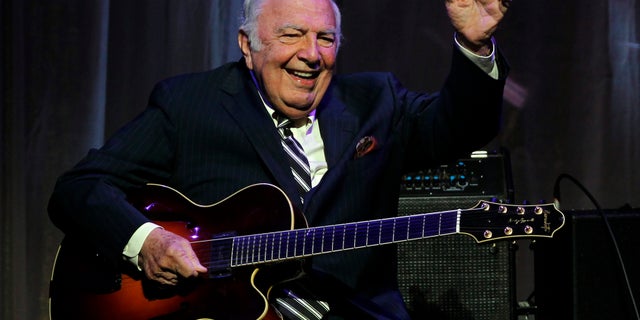 John "Bucky" Pizzarelli after being inducted into the New Jersey Hall of Fame during the induction ceremony in Newark, N.J. in 2011. The virtuoso who performed mostly modern interpretations from the Great American Songbook died on Wednesday, April 1, 2020, in his home in Saddle River, N.J., at the age of 94. (AP Photo/Rich Schultz, File)