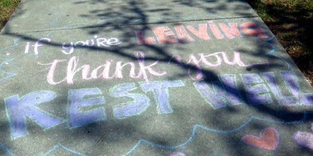 A message written in chalk that reads, "If you're leaving, thank you, rest well," on a sidewalk at Ochsner Medical Center in New Orleans. (AP Photo/Stacey Plaisance)
